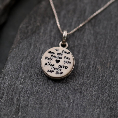 Silberner Jerusalem-Stein-Anhänger mit  dem Wort „Shalom“ in verschiedenen Sprachen