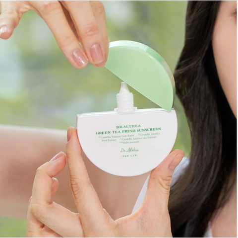 Dr.Althea Sonnencreme geöffnet mit Tropfspitze, Anwendung in den Händen einer Frau