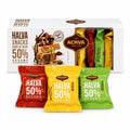 Halva Geschenkbox mit Riegeln in 3 Sorten, davor einzeln verpackte Riegel in Rot, Gelb und Grün