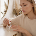 Maybelline Express Finish Nagellack transparent, Frau lackiert sich am Schminktisch den Fingernagel