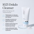 Round Lab 1025 Dokdo Cleanser Tube auf einer Wasserschale mit Salzkristallen, daneben vier Vorteile